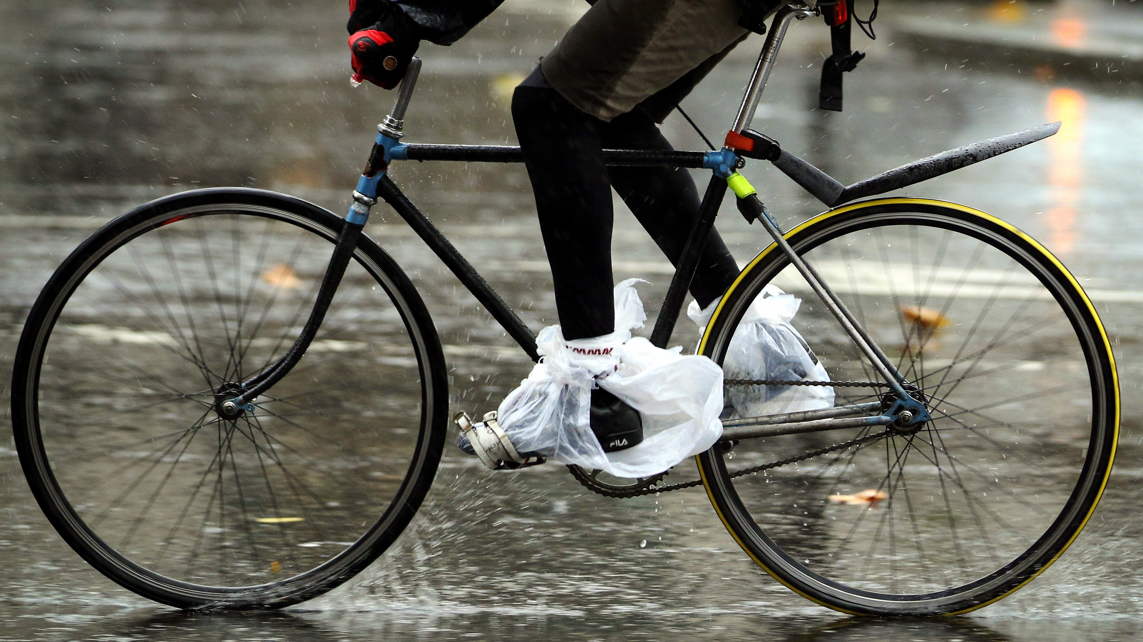 človek_bicykel_dážď_vrecká na nohách_pádluje_c